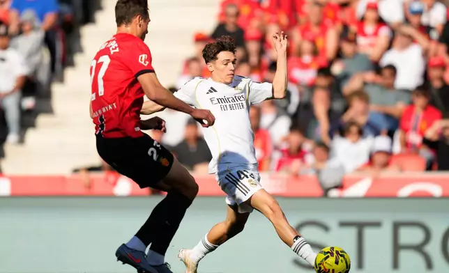 Mallorca's David Lopez guards Real Madrid's Thiago Pitarch Pinar during a La Liga soccer match between Mallorca and Real Madrid in Palma de Mallorca, Spain, Saturday, April 4, 2026. (AP Photo/Jose Breton)