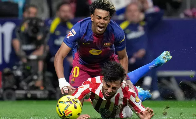Barcelona's Lamine Yamal, top is tackled and fouled by Atletico Madrid's Nico Gonzalez, who receives a second yellow card and is then sent off during a La Liga soccer match between Atletico Madrid and Barcelona in Madrid, Spain, Saturday, April 4, 2026. (AP Photo/Bernat Armangue)