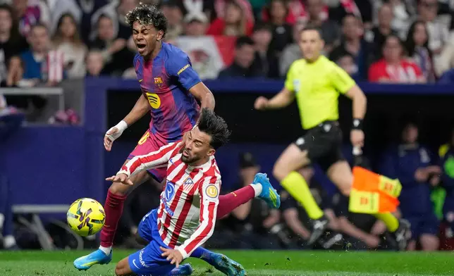 Barcelona's Lamine Yamal, top is tackled and fouled by Atletico Madrid's Nico Gonzalez, who receives a second yellow card and is then sent off during a La Liga soccer match between Atletico Madrid and Barcelona in Madrid, Spain, Saturday, April 4, 2026. (AP Photo/Bernat Armangue)