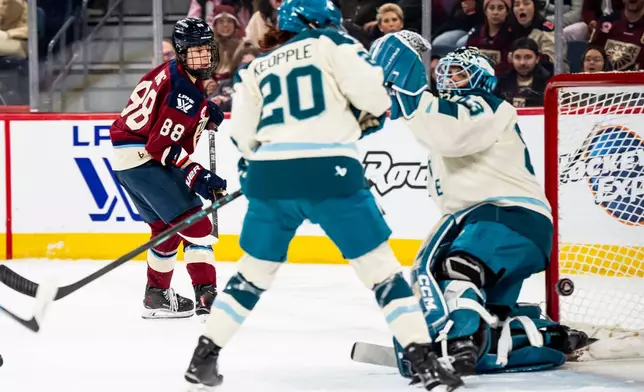 Montreal Victoire's Skylar Irving (88) scores on Seattle Torrent goaltender Hannah Murphy (83) while Torrent's Mariah Keopple (20) defends, during the second period of a PWHL hockey gamen in Laval, Que., on Tuesday, April 7, 2026. (Christopher Katsarov/The Canadian Press via AP)