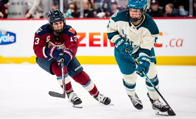 Montreal Victoire's Alexandra Labelle (13) defends against Seattle Torrent's Anna Wilgren (5) during the second period of a PWHL hockey gamen in Laval, Que., on Tuesday, April 7, 2026. (Christopher Katsarov/The Canadian Press via AP)