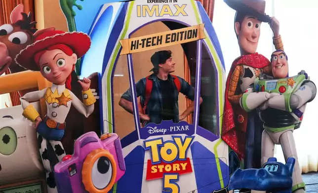 CinemaCon attendee Patrick Dougall strikes a pose inside an advertisement for the upcoming film "Toy Story 5" during the opening day of CinemaCon 2026, the official convention of Cinema United, on Monday, April 13, 2026, at Caesars Palace in Las Vegas. (AP Photo/Chris Pizzello)
