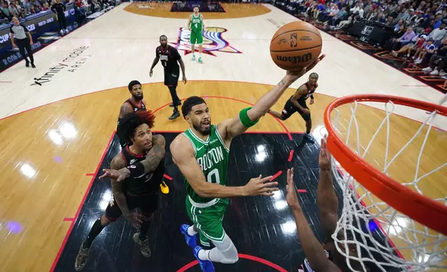 Boston Celtics' Jayson Tatum, right, goes up for a shot past Philadelphia 76ers' Kelly Oubre Jr. during the second half of Game 3 in a first-round NBA playoffs basketball series Friday, April 24, 2026, in Philadelphia. (AP Photo/Matt Slocum)
