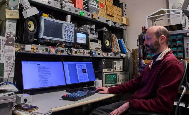 Brian Mayton, a member of the Living Observatory and research affiliate at Massachusetts Institute of Technology Media Lab, reads research papers at his desk at MIT, Wednesday, March 25, 2026 in Cambridge Mass. (Jamie Jiang/MIT Graduate Program in Science Writing via AP)