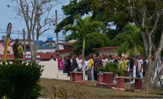 Pardoned prisoners stand before men in uniform inside La Lima penitentiary before being released in Guanabo, Cuba, Friday, April 3, 2026. (AP Photo/Ramon Espinosa)