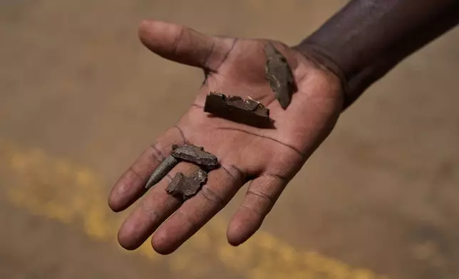 A member of Jasmar's demining team displays pieces of shrapnel found in a mine-affected area in Khartoum, Sudan, Tuesday, April 21, 2026. (AP Photo/Bernat Armangue)