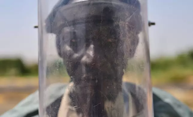 A member of Jasmar's demining team wears personal protective equipment, or PPE, at a demining site in Khartoum, Sudan, Tuesday, April 21, 2026. (AP Photo/Bernat Armangue)