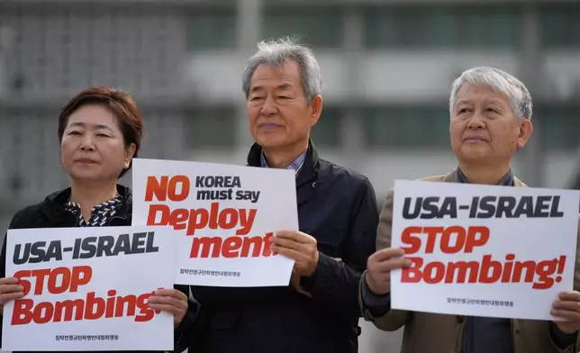 Members of civic groups hold signs against the U.S. and Israel attacks on Iran near the U.S. Embassy in Seoul, South Korea, Wednesday, April 1, 2026. (AP Photo/Lee Jin-man)