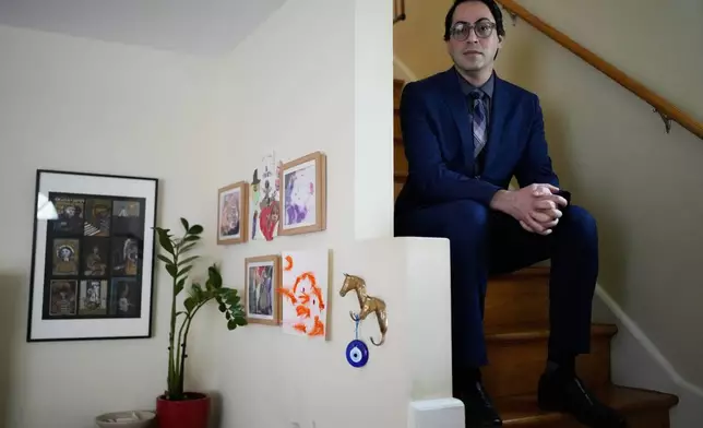 Ali Tarokh sits on a stair at his home in Chicago, Wednesday, March 25, 2026. (AP Photo/Nam Y. Huh)