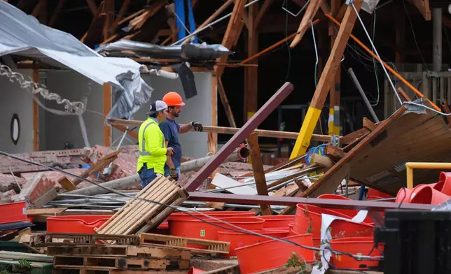 People stand amid debris following a storm in Mineral Wells, Texas, Wednesday, April 29, 2026. (AP Photo/Julio Cortez)