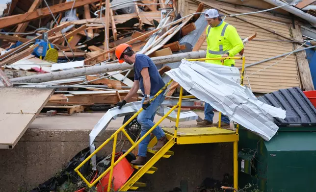 People clear debris following a storm in Mineral Wells, Texas, Wednesday, April 29, 2026. (AP Photo/Julio Cortez)