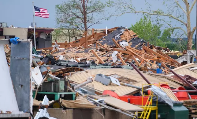 A United States flag waves over debris following a storm in Mineral Wells, Texas, Wednesday, April 29, 2026. (AP Photo/Julio Cortez)