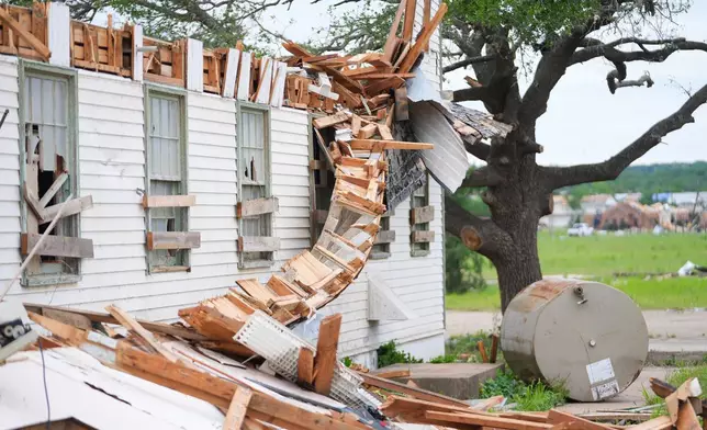 A damaged home is surrounded by debris following a storm in Mineral Wells, Texas, Wednesday, April 29, 2026. (AP Photo/Julio Cortez)