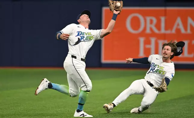 Tampa Bay Rays second baseman Ben Williamson, left, makes the catch on a ball popped up by Minnesota Twins' Royce Lewis (not shown) during the fourth inning of a baseball game Friday, April 24, 2026, in St. Petersburg, Fla. (AP Photo/Jason Behnken)