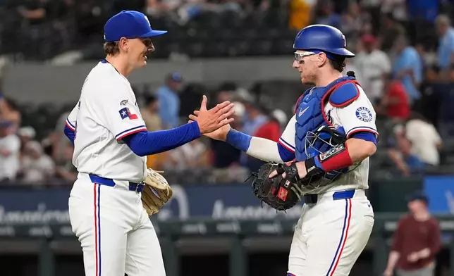 Texas Rangers relief pitcher Peyton Gray, left, celebrates with catcher Danny Jansen, right, after the team's win in a baseball game against the Pittsburgh Pirates Thursday, April 23, 2026, in Arlington, Texas. (AP Photo/Tony Gutierrez)