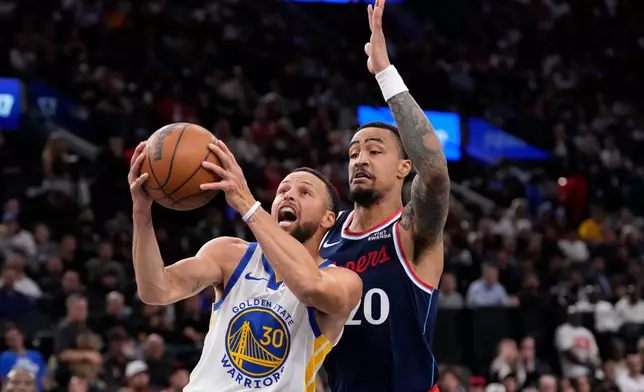Golden State Warriors guard Stephen Curry, left, shoots as LA Clippers forward John Collins defends during the first half of an NBA play-in tournament basketball game Wednesday, April 15, 2026, in Inglewood, Calif. (AP Photo/Mark J. Terrill)