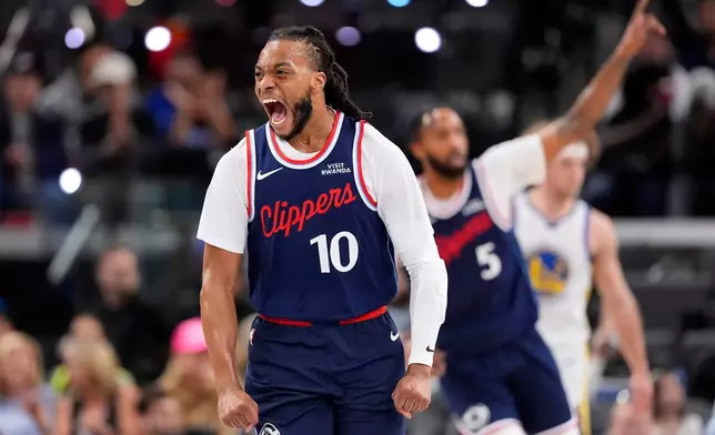 LA Clippers guard Darius Garland, left, celebrates after scoring during the first half of an NBA play-in tournament basketball game against the Golden State Warriors, Wednesday, April 15, 2026, in Inglewood, Calif. (AP Photo/Mark J. Terrill)