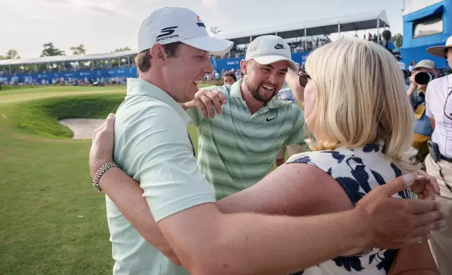 Matt Fitzpatrick, left, of England, hugs his mother Susan Fitzpatrick, right, after he and brother Alex Fitzpatrick, center, won the PGA Zurich Classic of New Orleans golf tournament, Sunday, April 26, 2026, in Avondale, La. (AP Photo/Matthew Hinton)