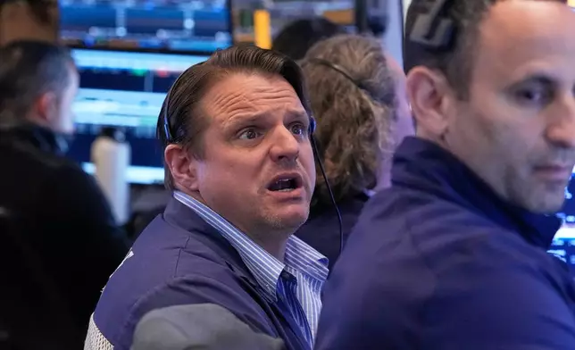 Trader Michael Milano, left, works on the floor of the New York Stock Exchange, Monday, April 20, 2026. (AP Photo/Richard Drew)