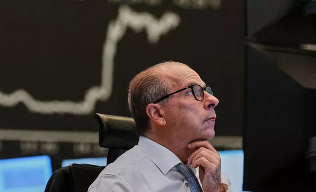 A broker watches his screens at the stock market in Frankfurt, Germany, Friday, April 17, 2026. (AP Photo/Michael Probst)