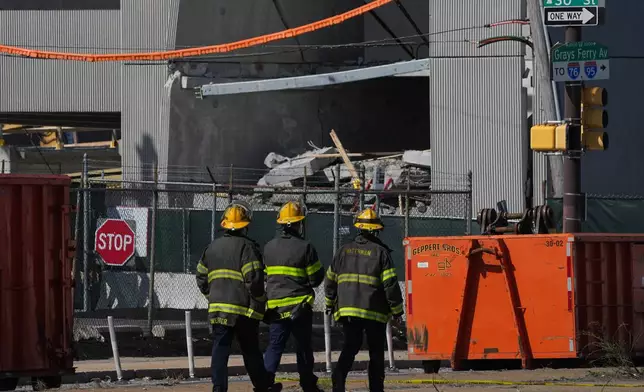 First responders walk near a partially collapsed parking garage in Philadelphia, Thursday, April 9, 2026. (AP Photo/Matt Rourke)