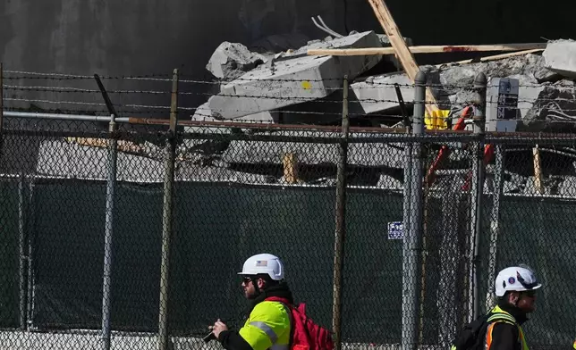 First responders inspect a partially collapsed parking garage in Philadelphia, Thursday, April 9, 2026. (AP Photo/Matt Rourke)