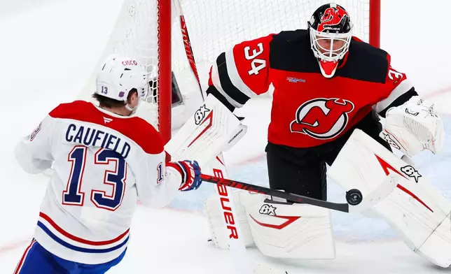 Montréal Canadiens right wing Cole Caufield (13) shoots against New Jersey Devils goaltender Jake Allen (34) during the third period of an NHL hockey game, Saturday, April 4, 2026, in Newark, N.J. (AP Photo/Noah K. Murray)