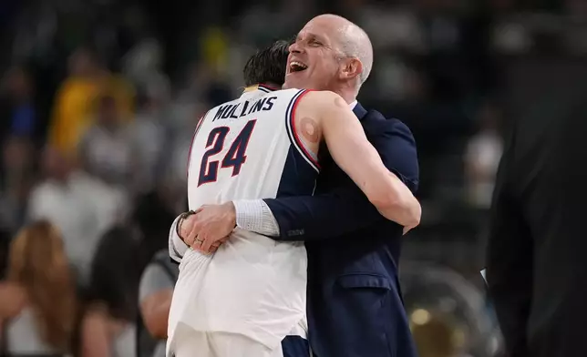 UConn's Braylon Mullins (24) and head coach Dan Hurley celebrate after defeating Illinois in an an NCAA college basketball tournament semifinal game at the Final Four, Saturday, April 4, 2026, in Indianapolis. (AP Photo/Michael Conroy)