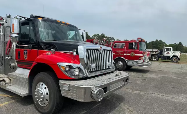 Fire trucks are staged outside the command center in Nahunta, Ga., where officials are coordinating the fight against a wildfire Wednesday, April 22, 2026.(AP Photo/Russ Bynum)