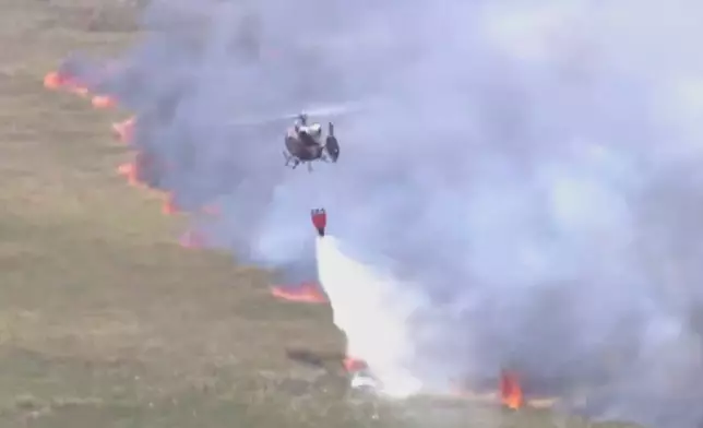 This image taken from a WSVN video shows firefighters battling a wildfire Wednesday, April 22, 2026, in Broward County, Fla. (WSVN/ABC Miami via AP)