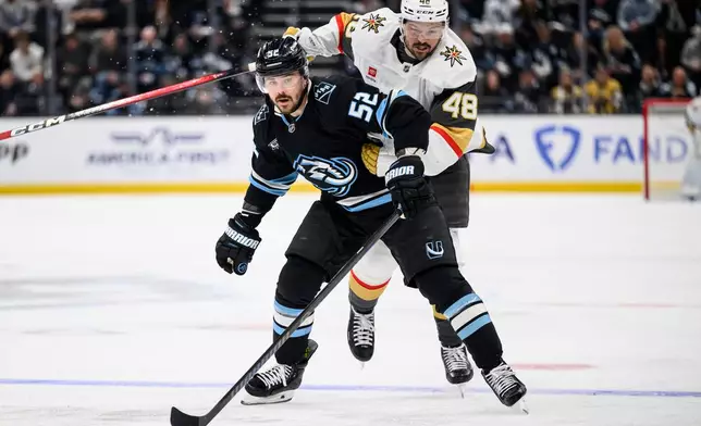 Utah Mammoth defenseman MacKenzie Weegar (52) and Vegas Golden Knights center Tomas Hertl (48) look to play the puck during the overtime period of Game 4 of a first-round NHL hockey Stanley Cup playoff series, Monday, April 27, 2026, in Salt Lake City. (AP Photo/Tyler Tate)