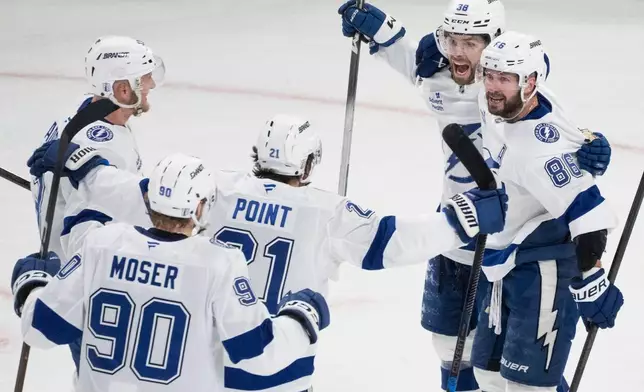 Tampa Bay Lightning's Brandon Hagel (38) celebrates his goal over Montreal Canadiens with teammates Nikita Kucherov (86), Brayden Point (21), J.J. Moser (90) and Darren Raddysh (43) during the third period of Game 4 in a first-round NHL hockey Stanley Cup playoff series, in Montreal, Sunday, April 26, 2026. (Christinne Muschi/The Canadian Press via AP)