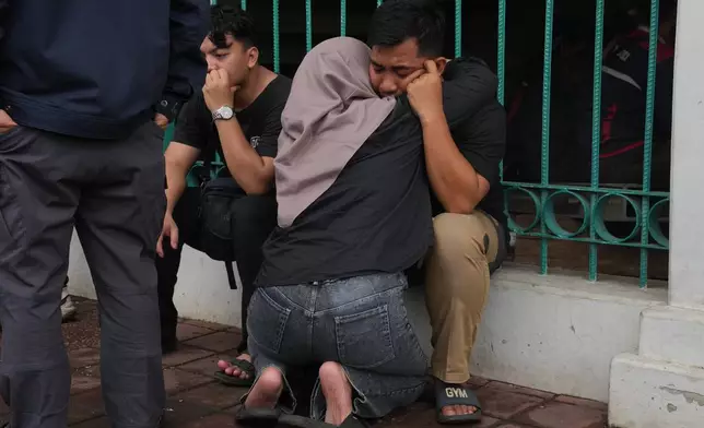 Relatives of victims comfort each other after a train collision in Bekasi, Indonesia, Tuesday, April 28, 2026. (AP Photo/Tatan Syuflana)
