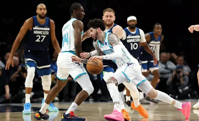 Charlotte Hornets guard LaMelo Ball (1) works around Minnesota Timberwolves guard Donte DiVincenzo (0) during the first half of an NBA basketball game, Sunday, April 5, 2026, in Minneapolis. (AP Photo/Matt Krohn)