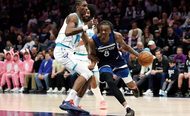 Minnesota Timberwolves guard Bones Hyland, right, works around Charlotte Hornets forward Moussa Diabate (14) during the first half of an NBA basketball game, Sunday, April 5, 2026, in Minneapolis. (AP Photo/Matt Krohn)