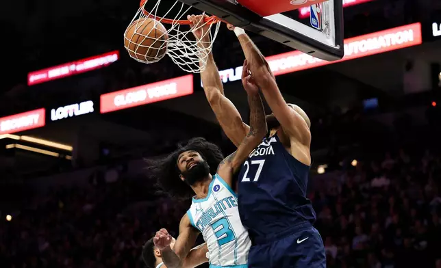 Minnesota Timberwolves center Rudy Gobert, right, winks over Charlotte Hornets guard Coby White (3) during the first half of an NBA basketball game, Sunday, April 5, 2026, in Minneapolis. (AP Photo/Matt Krohn)