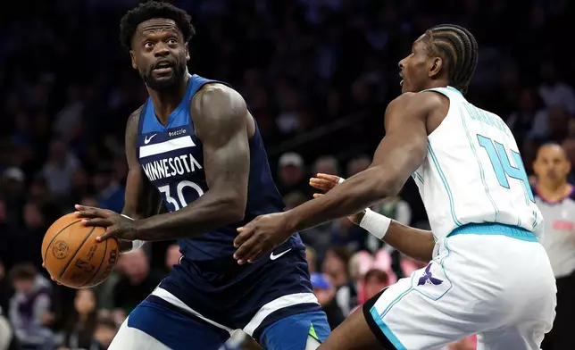 Minnesota Timberwolves forward Julius Randle, left, looks to shoot as Charlotte Hornets forward Moussa Diabate (14) defends during the first half of an NBA basketball game, Sunday, April 5, 2026, in Minneapolis. (AP Photo/Matt Krohn)