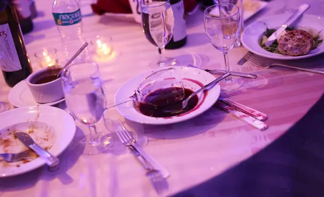 An abandoned wine glass sits in a bowl after an incident occurred at the White House Correspondents Dinner at the Washington Hilton, Saturday, April 25, 2026, in Washington. (AP Photo/Tom Brenner)