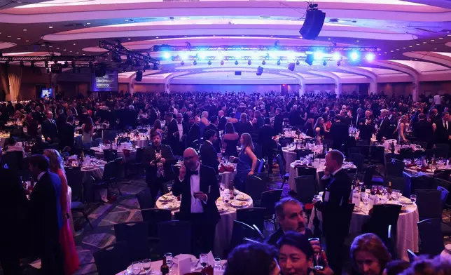 Guest evacuate after an incident at the White House Correspondents Dinner, Saturday, April 25, 2026, in Washington. (AP Photo/Tom Brenner)