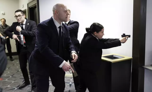 Members of law enforcement respond during the White House Correspondents Dinner, Saturday, April 25, 2026, in Washington. (AP Photo/Tom Brenner)