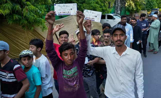 Fans show their tickets as they arrive for Pakistan Super League first eliminator cricket match between Multan Sultans and Hyderabad Kingsmen at the Gaddafi Stadium in Lahore, Pakistan, Wednesday, April 29, 2026. (AP Photo/K.M. Chaudary)
