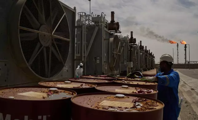 FILE - A worker collects engine oil as he works at a degassing station at Zubair oil field near Basra, Iraq, March 28, 2026. (AP Photo/Leo Correa, File)