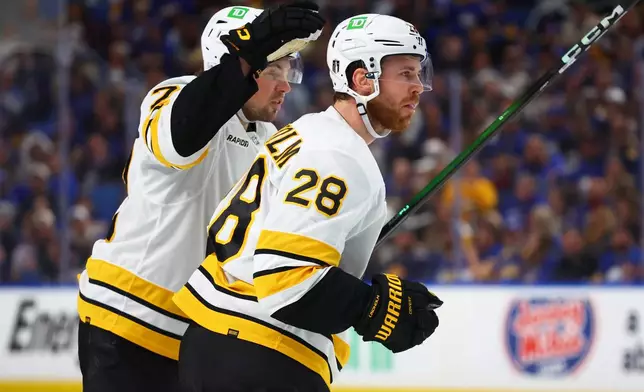 Boston Bruins center Elias Lindholm (28) celebrates his goal with defenseman Charlie McAvoy (73)during the second period in Game 5 of a first-round NHL hockey Stanley Cup playoff series against the Buffalo Sabres Tuesday, April 28, 2026, in Buffalo, N.Y. (AP Photo/Jeffrey T. Barnes)