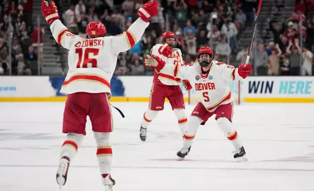 Denver players celebrate after Denver forward Kyle Chyzowski (16) scored against Wisconsin in the third period of the championship game at the NCAA Frozen Four men's college hockey tournament Saturday, April 11, 2026, in Las Vegas. (AP Photo/John Locher)
