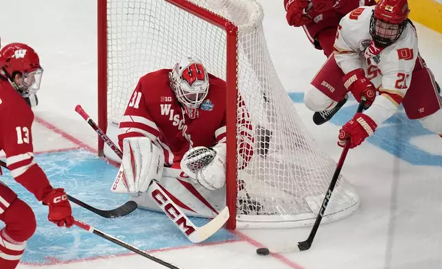 Denver forward Clarke Caswell (25) attempts a shot on Wisconsin goaltender Daniel Hauser (31) in the first period of the championship game at the NCAA Frozen Four men's college hockey tournament Saturday, April 11, 2026, in Las Vegas. (AP Photo/John Locher)