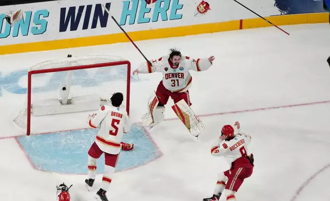 Denver goaltender Johnny Hicks (31) celebrates with teammates after defeating Wisconsin in the championship game at the NCAA Frozen Four men's college hockey tournament Saturday, April 11, 2026, in Las Vegas. (AP Photo/John Locher)