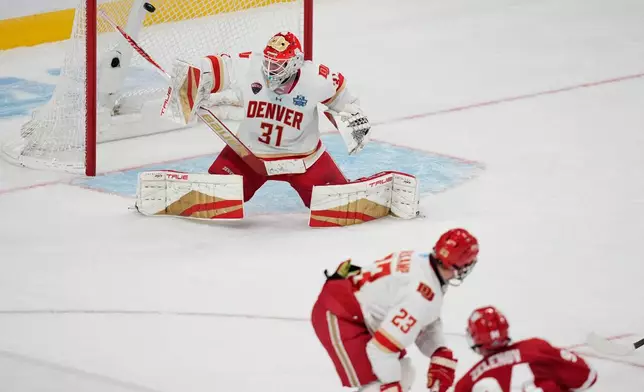 Wisconsin forward Vasily Zelenov (94) scores on Denver goaltender Johnny Hicks (31) in the first period of the championship game at the NCAA Frozen Four men's college hockey tournament Saturday, April 11, 2026, in Las Vegas. (AP Photo/John Locher)