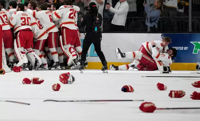 Denver players celebrate after defeating Wisconsin in the championship game at the NCAA Frozen Four men's college hockey tournament Saturday, April 11, 2026, in Las Vegas. (AP Photo/John Locher)