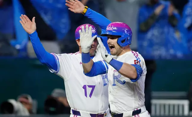 Kansas City Royals' Lane Thomas, right, celebrates after hitting a walkoff home run with third base coach Vance Wilson (17) during a baseball game against the Los Angeles Angels in Kansas City, Mo., Sunday, April 26, 2026. (AP Photo/Colin E. Braley)