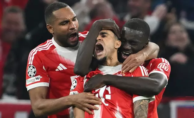 Bayern's Luis Diaz, center, celebrates with Dayot Upamecano right, and Jonathan Tah after scoring his their third goal during the Champions League quarterfinal second leg soccer match between Bayern Munich and Real Madrid in Munich, Germany, Wednesday, April 15, 2026. (Sven Hoppe/dpa via AP)